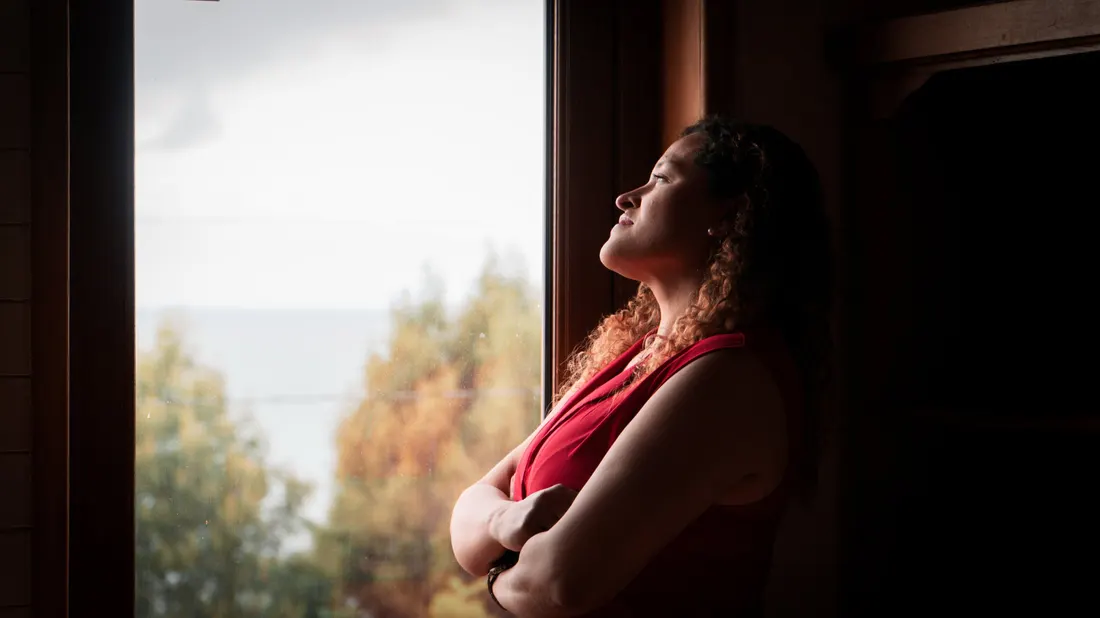Marcela mirando por la ventana